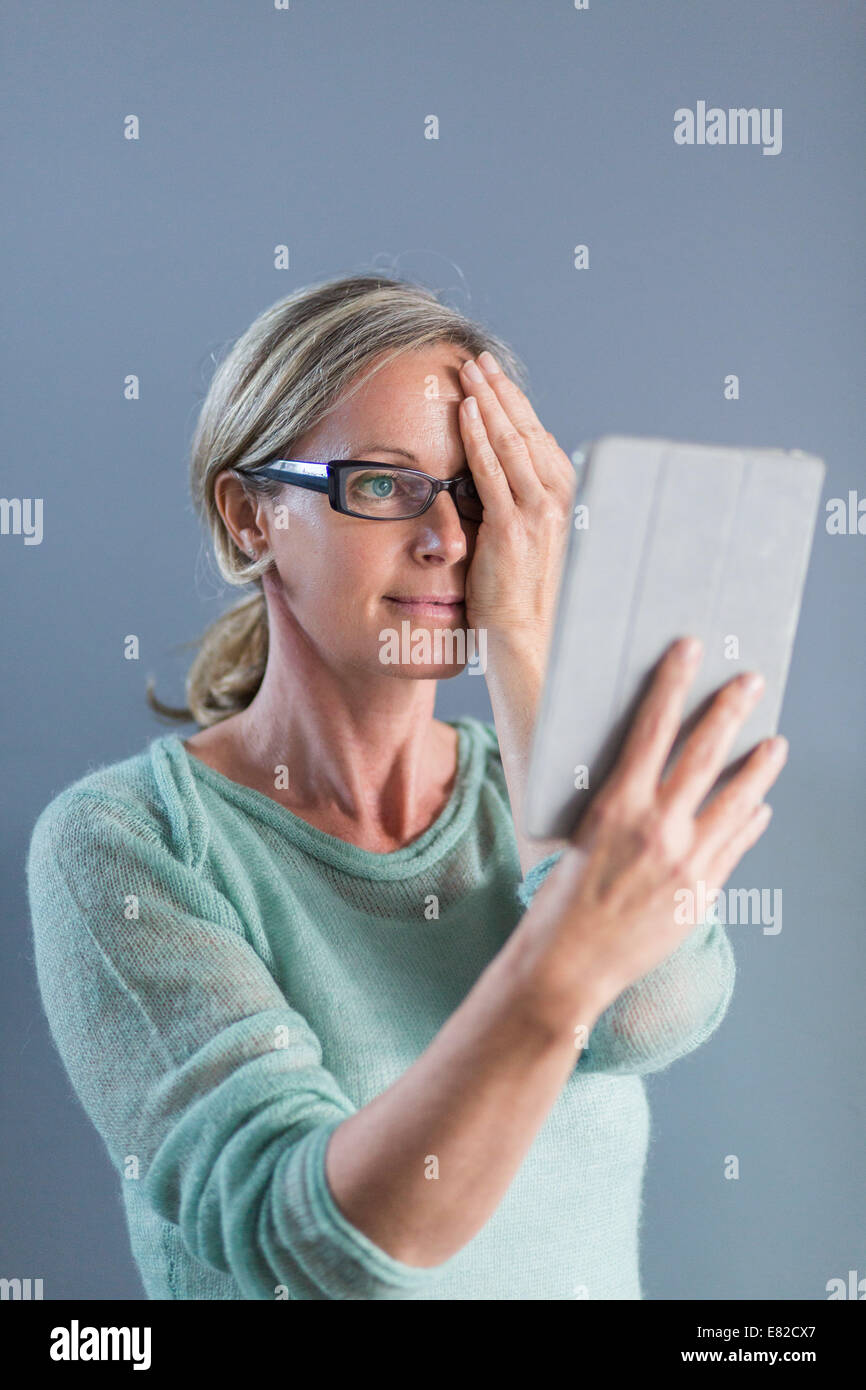 Senior woman looking at une grille d'Amsler pour détecter la dégénérescence maculaire. Banque D'Images