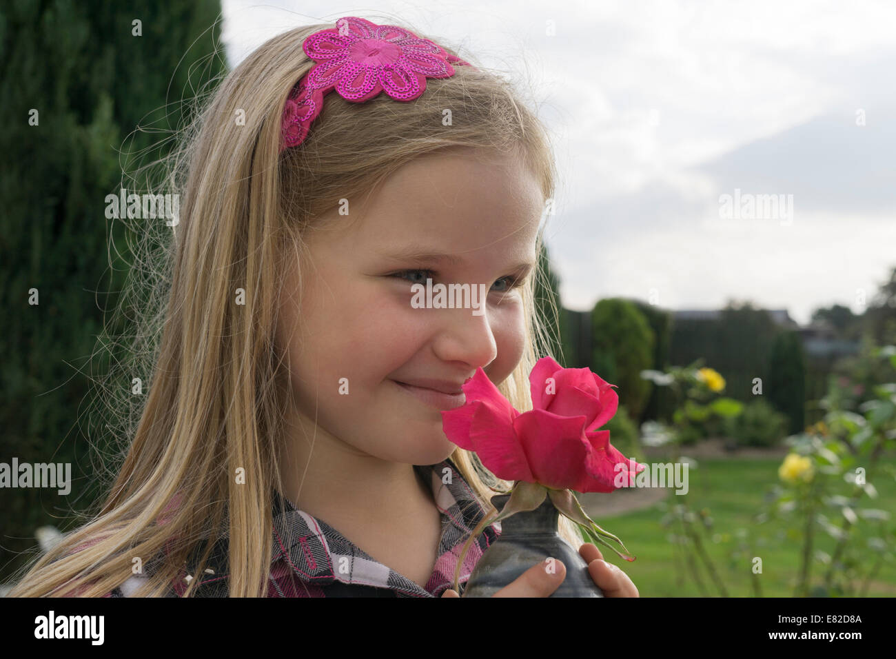 Jeune fille sentir une rose rouge. Banque D'Images