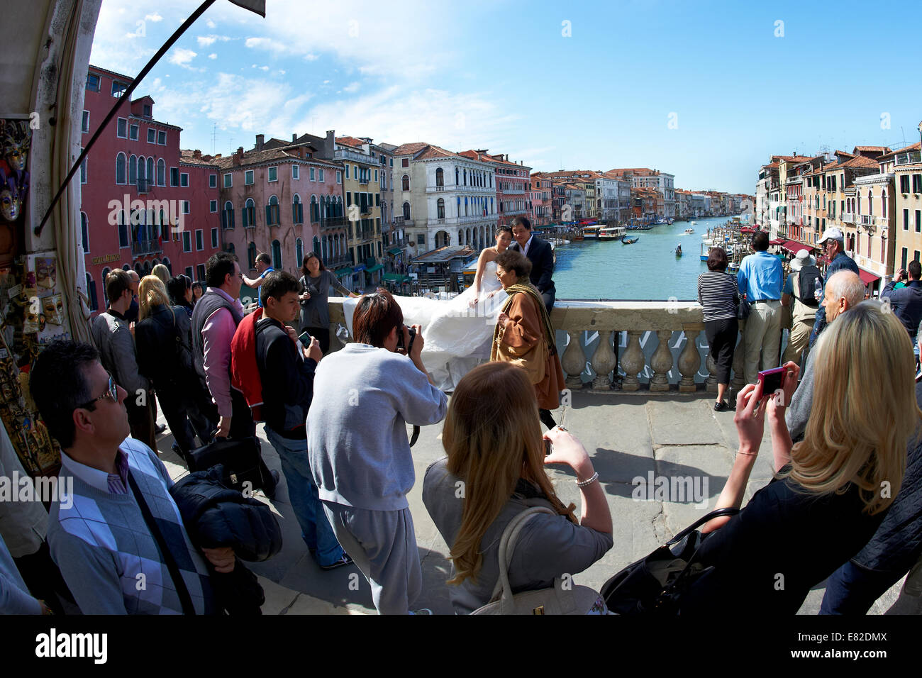 Asian couple nouvellement marié ayant leurs photos de mariage prises sur le pont du Rialto, Venise, Italie, avec Canal Grande comme toile de fond. Banque D'Images