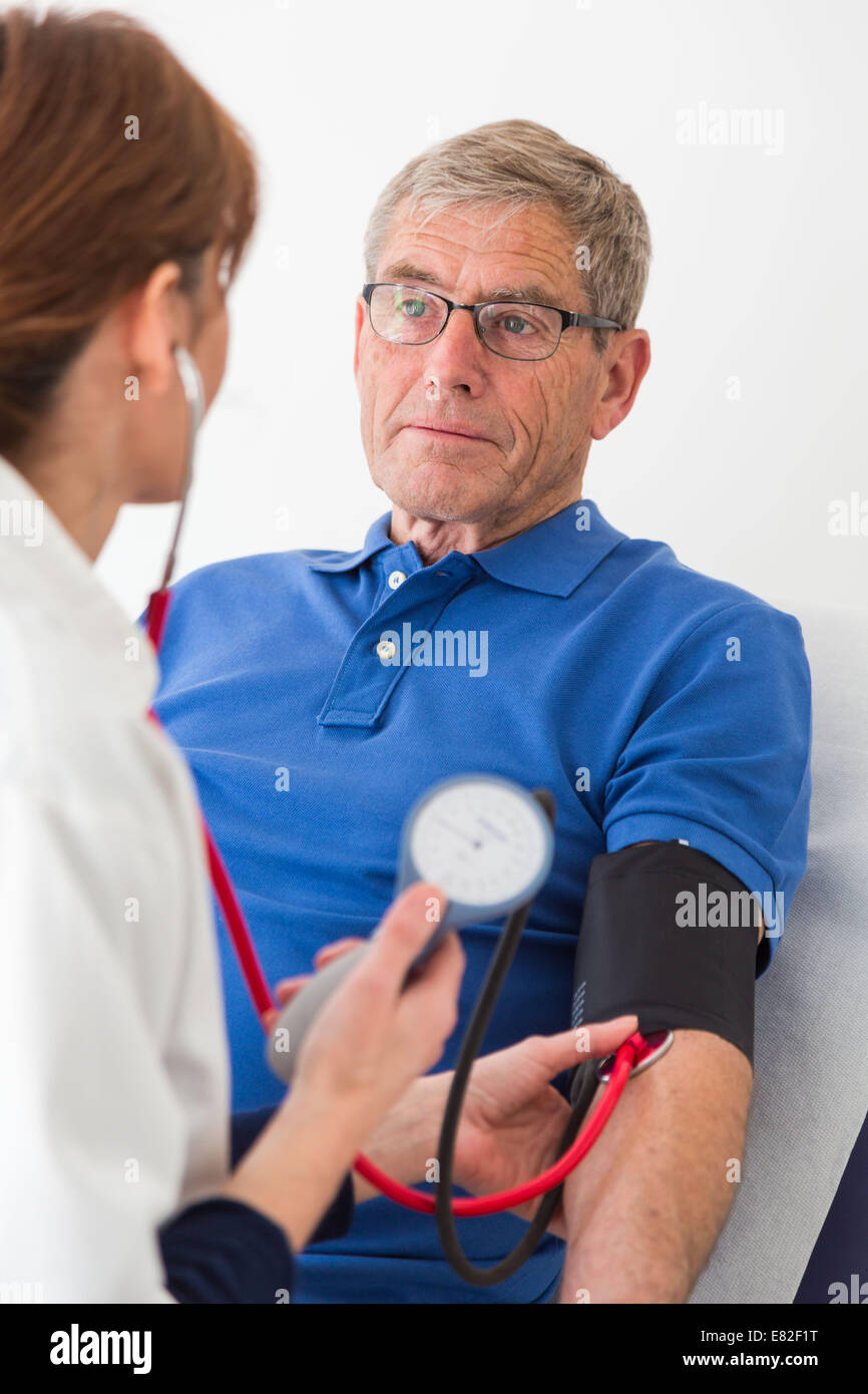 Médecin contrôle de la pression artérielle des patients âgés. Banque D'Images