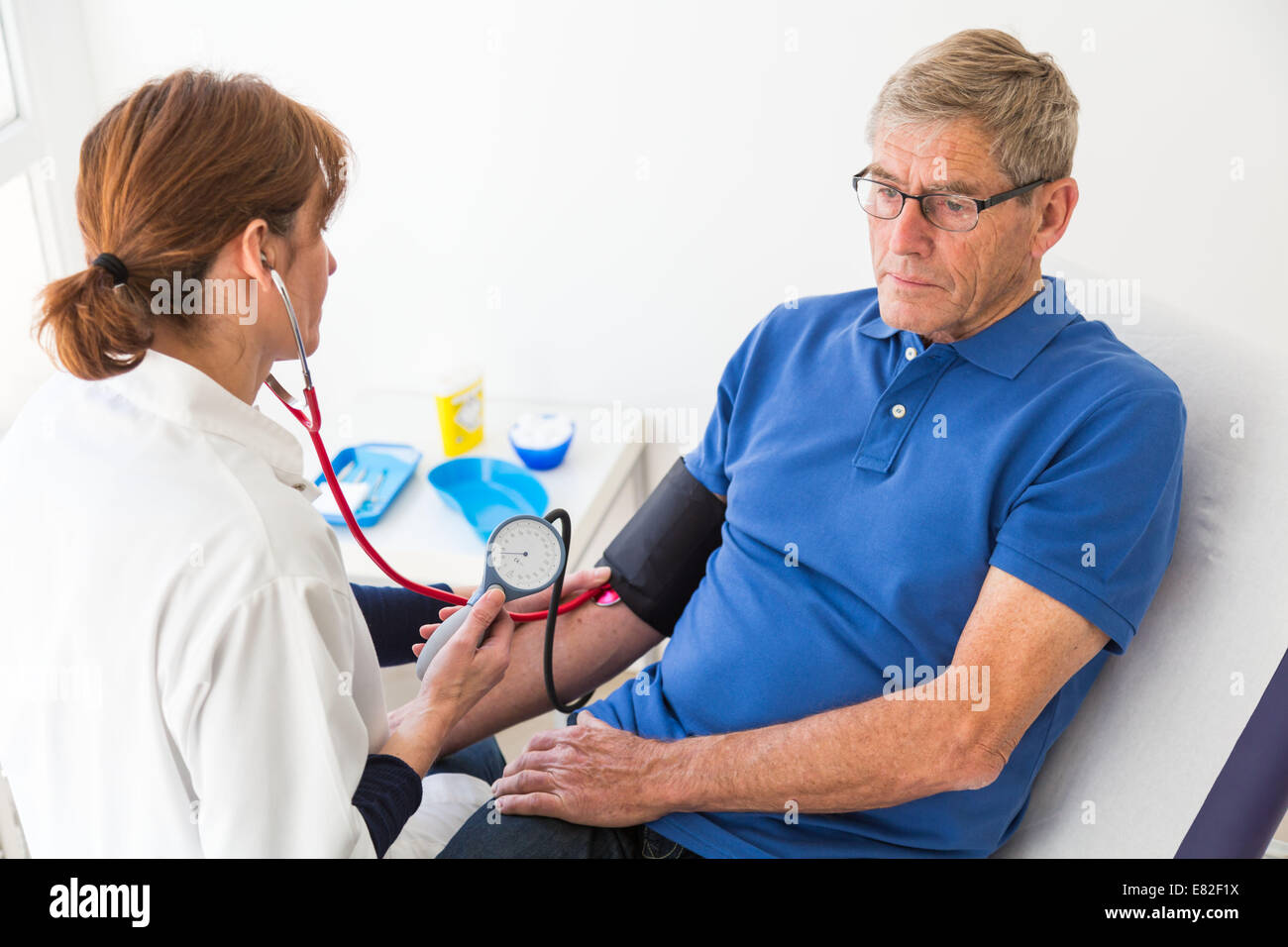 Médecin contrôle de la pression artérielle des patients âgés. Banque D'Images