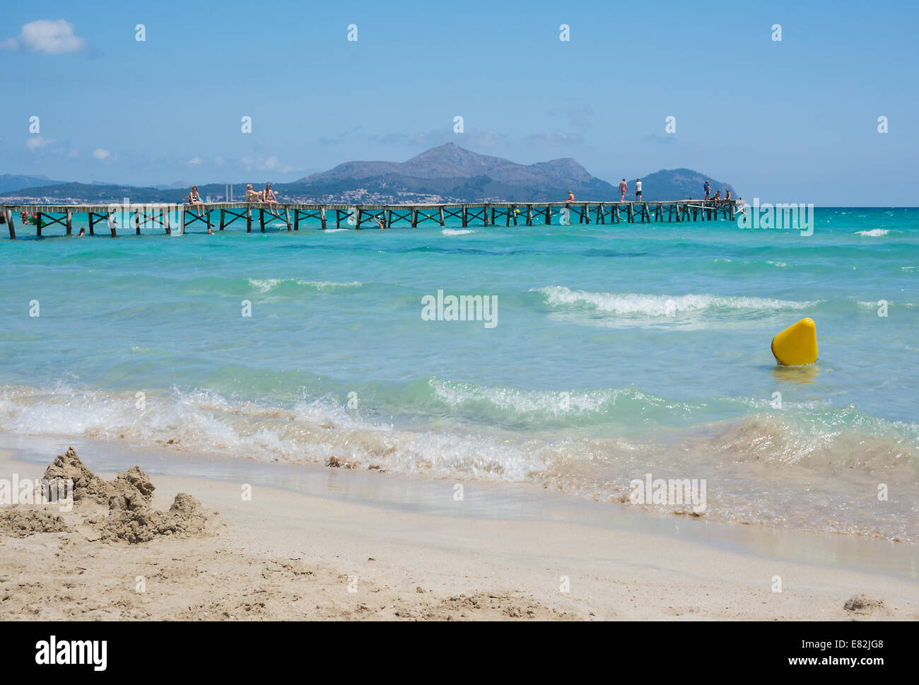 Emerald Beach avec de l'eau claire comme du cristal et des gens sur la jetée. Playa de Muro, Majorque, îles Baléares, Espagne. Banque D'Images