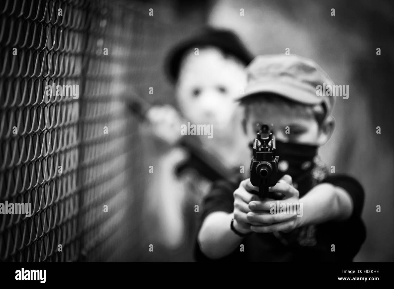 Garçon masqué visant avec pistolet jouet Banque D'Images