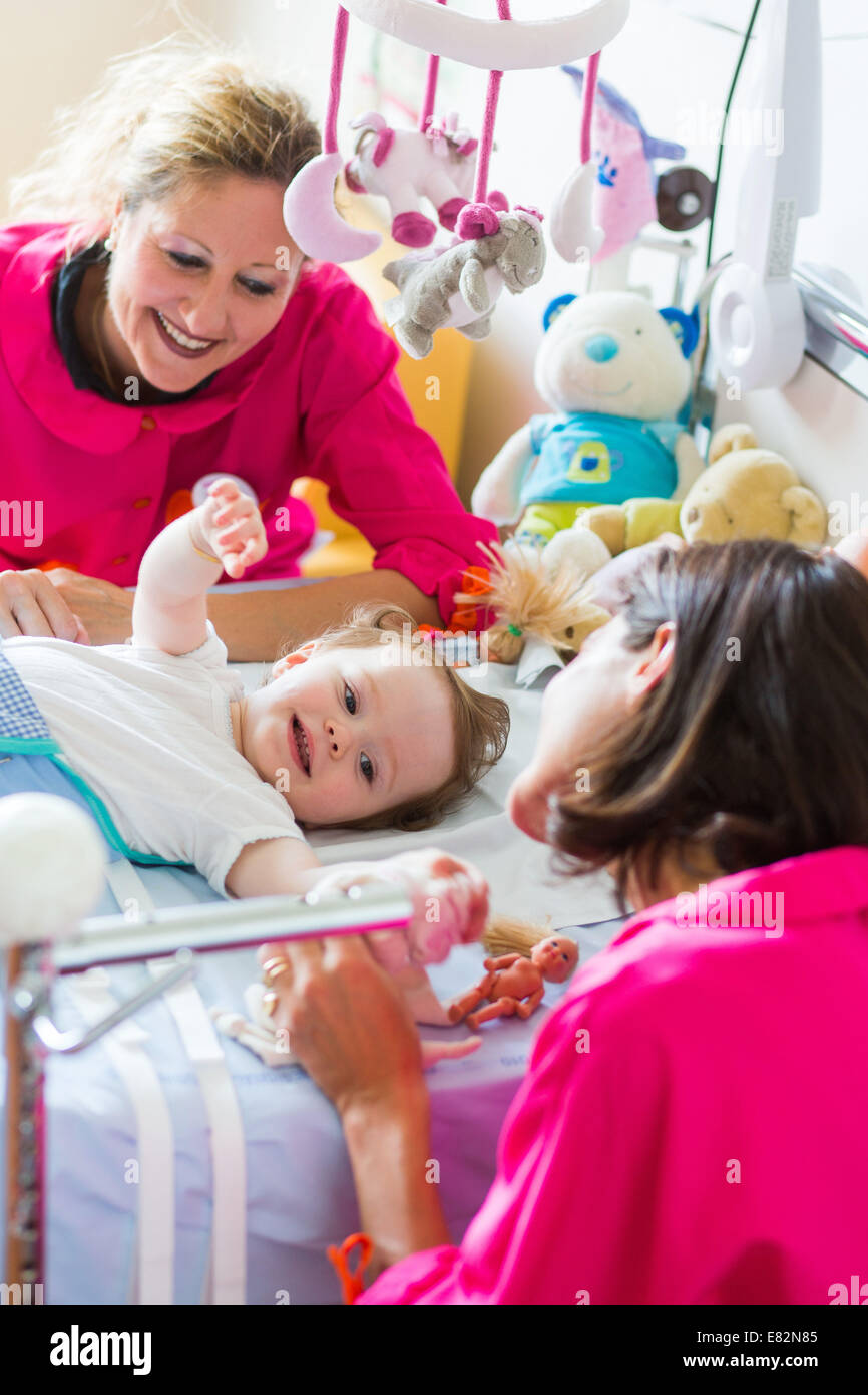 La rose 'Couches' des bénévoles de l'association Récréation et loisirs à l'hôpital avec 18 mois année vieux bébé fille touchée par Banque D'Images