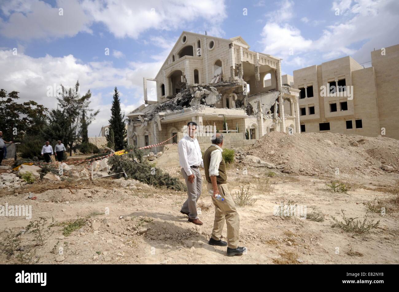 Bethléem, Proche-Orient. Sep 29, 2014. Palestiniens inspecter les décombres d'une maison après qu'il a été en partie démoli par les bulldozers israéliens à Abu Dis, ville située près de la ville cisjordanienne de Bethléem le 29 septembre, 2014. Credit : Emad Drimly/Xinhua/Alamy Live News Banque D'Images
