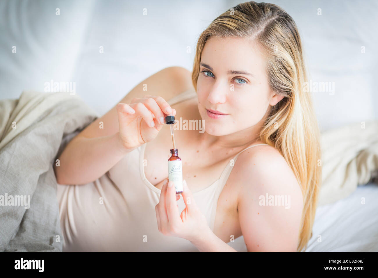 Femme à l'aide d'un remède de Bach (extrait de fleur de liquide). Banque D'Images