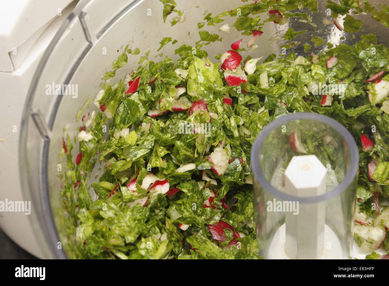 Les radis et les verts dans blender Raphanus sativus 'Scarlet Globe' Banque D'Images