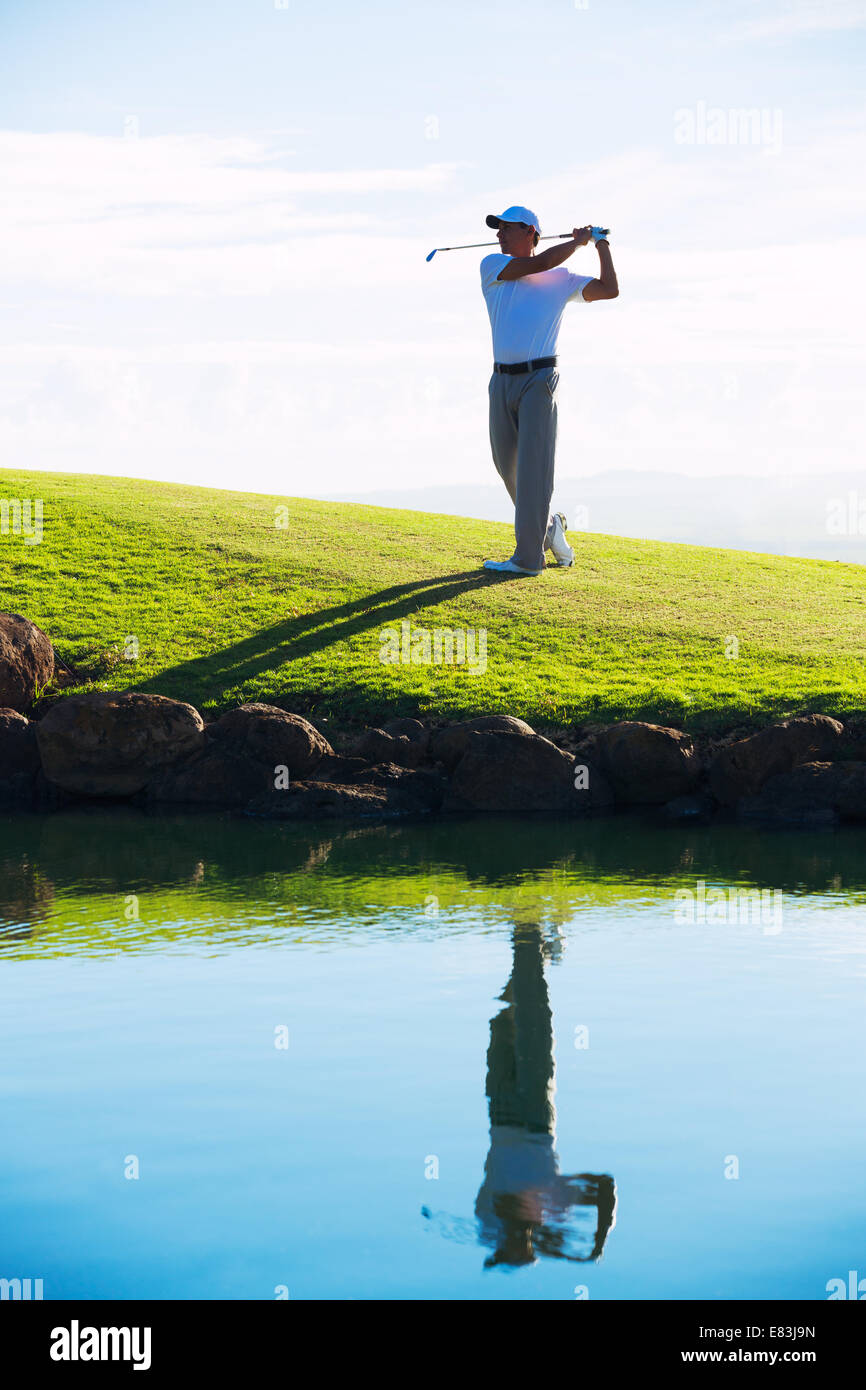 Silhouette of Man Playing Golf sur beau parcours, la réflexion dans l'eau Banque D'Images