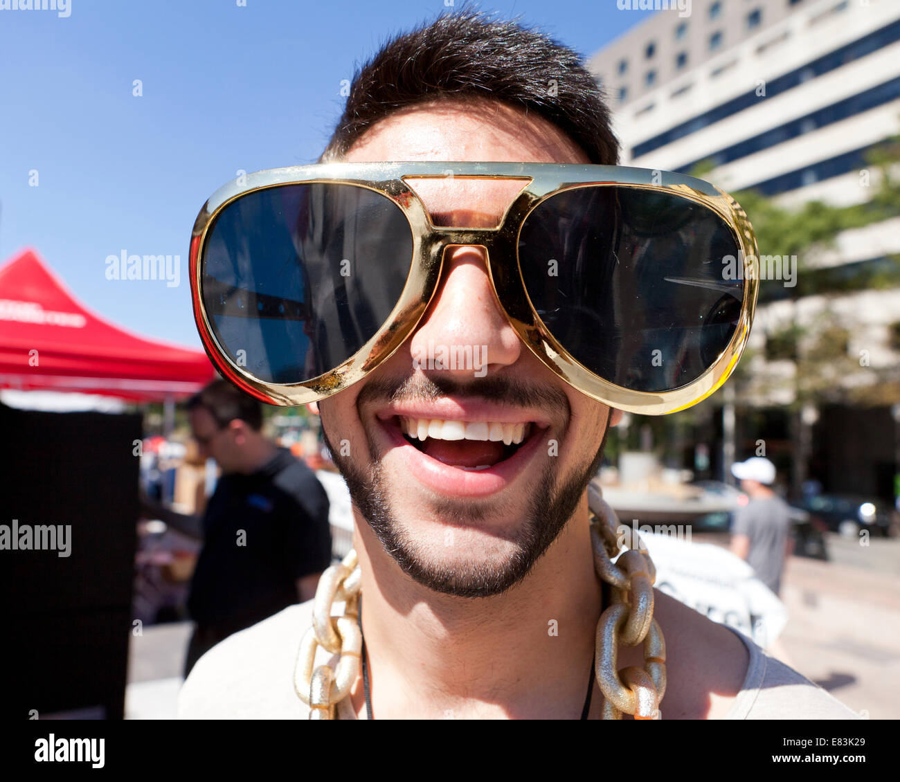 Jeune homme portant des lunettes de soleil nouveauté surdimensionnée drôle - USA Banque D'Images