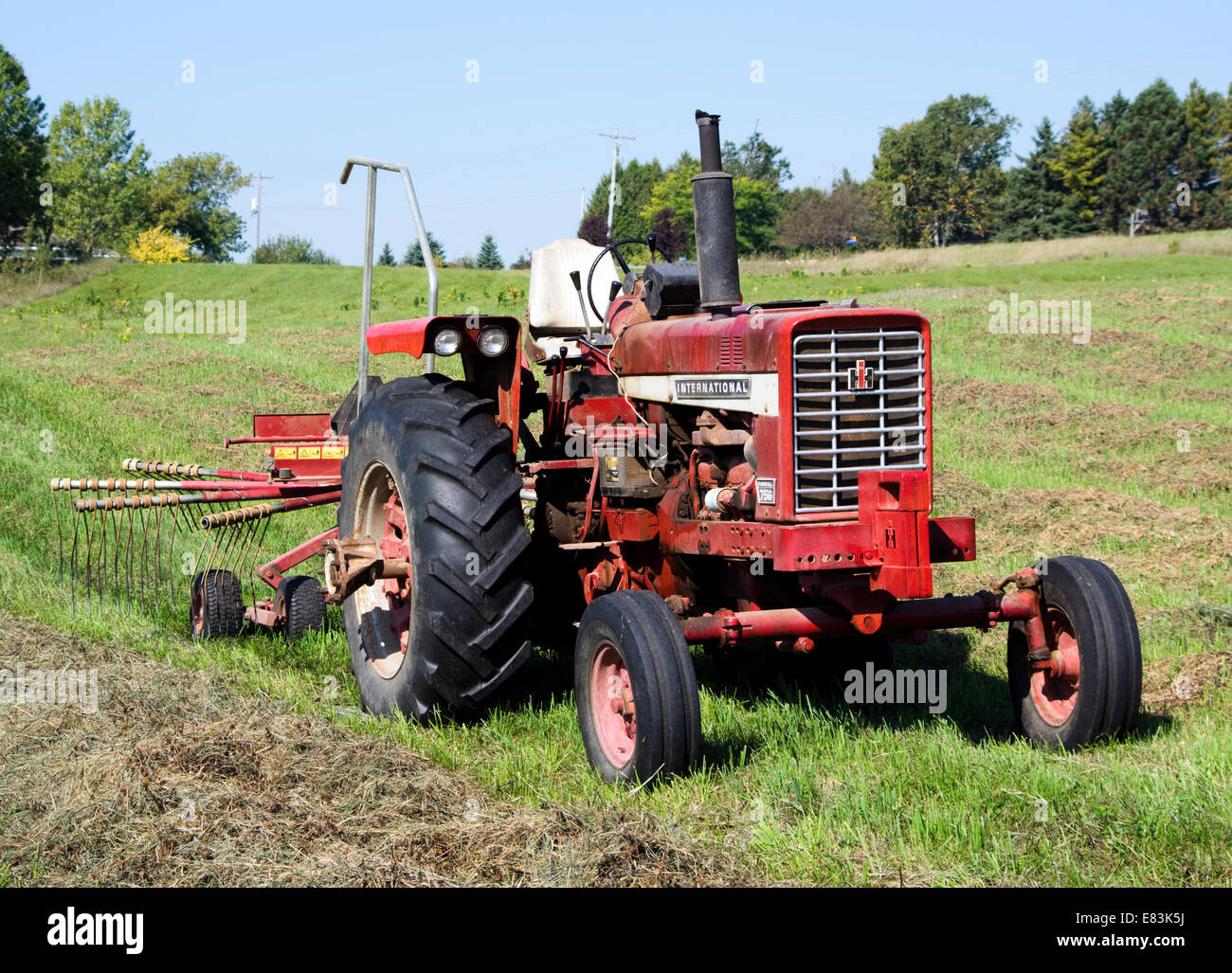 International Harvester tracteur agricole et hay rake stationné dans la zone Banque D'Images