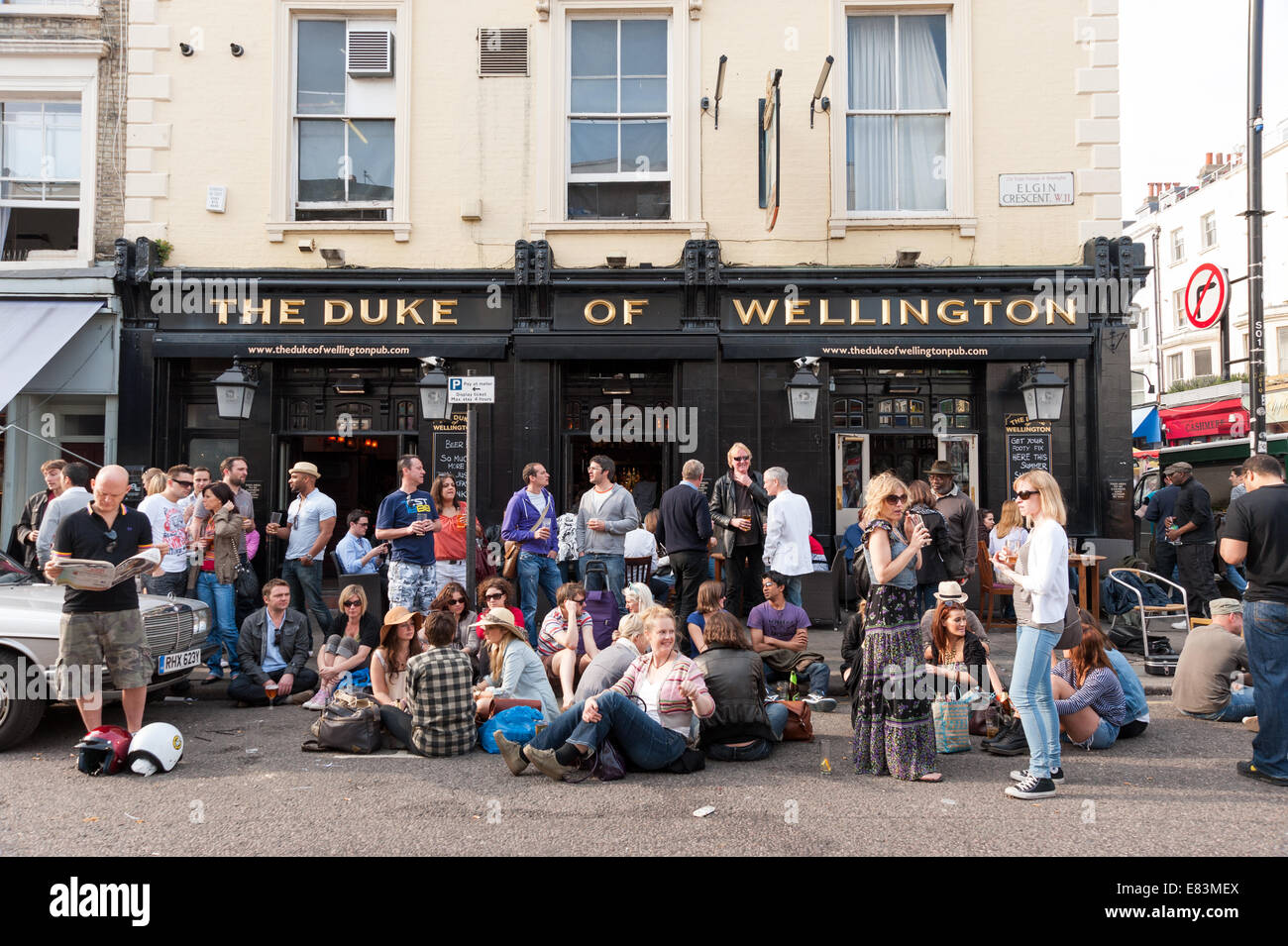 Les personnes qui boivent à l'extérieur du duc de Wellington pub sur Portobello Road, Notting Hill, London, England, UK Banque D'Images