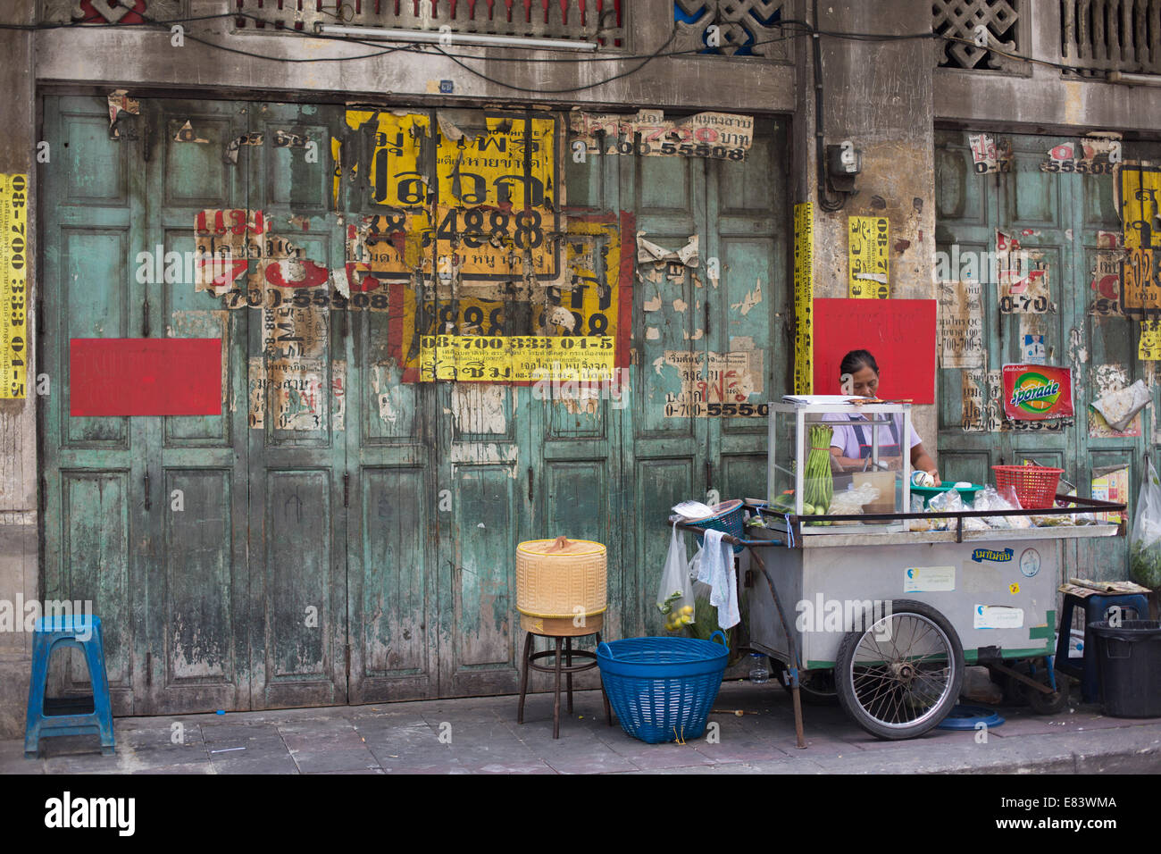 Food femelle porteur de préparer des aliments contre un mur vert, Chinatown, Bangkok, Thaïlande. Banque D'Images