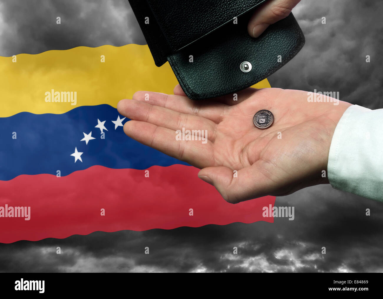 La main avec porte-monnaie et monnaie Bolivar vénézuélien devant le drapeau comme symbole de la menace d'une faillite nationale du pays. Banque D'Images