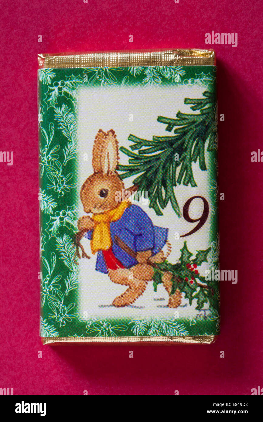 Compter jusqu'à Noël avec les barres de chocolat de l'avent isolé sur fond rouge - calendrier jour 9 de série de 24 Banque D'Images