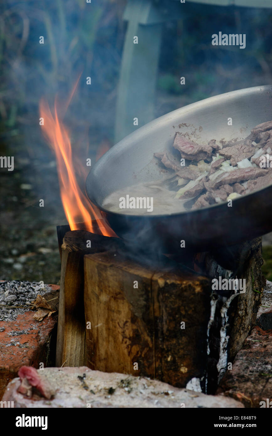 Bœuf Stroganoff cuit sur un feu ouvert à l'extérieur. Ce type de feu est connu comme un poêle finlandais, suédois ou bougie de Rocket Banque D'Images