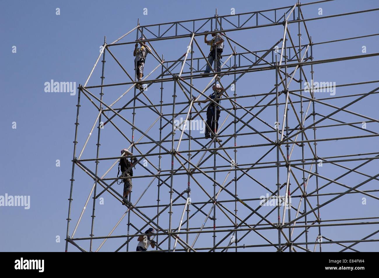 Les tiges d'acier de renforcement sur les travailleurs de la construction d'un grand stand d'éclairage pour un spectacle de musique en plein air Banque D'Images