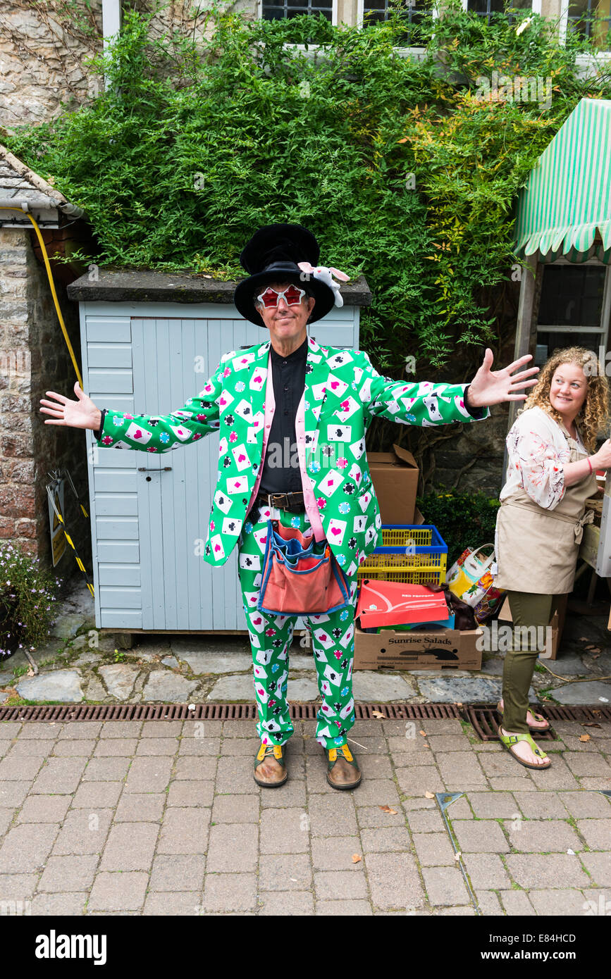 Devon Dartington Angleterre. Un magicien vêtu d'un costume vert décoré d'aces d'un jeu de cartes et des jetons. Banque D'Images