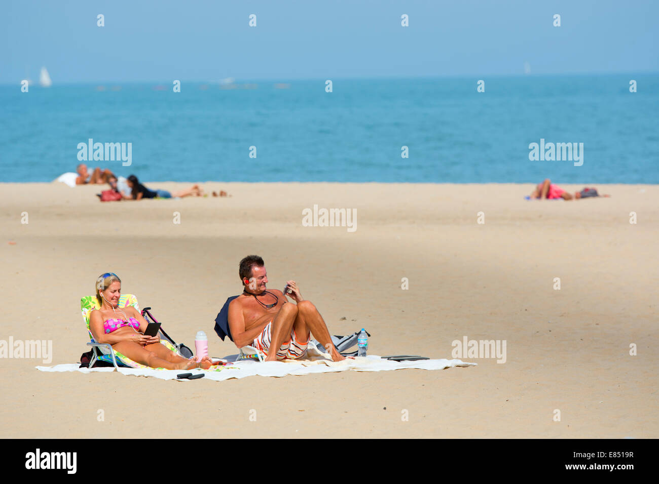 Couple on Beach Oak Street Beach, Chicago en utilisant les appareils mobiles Banque D'Images