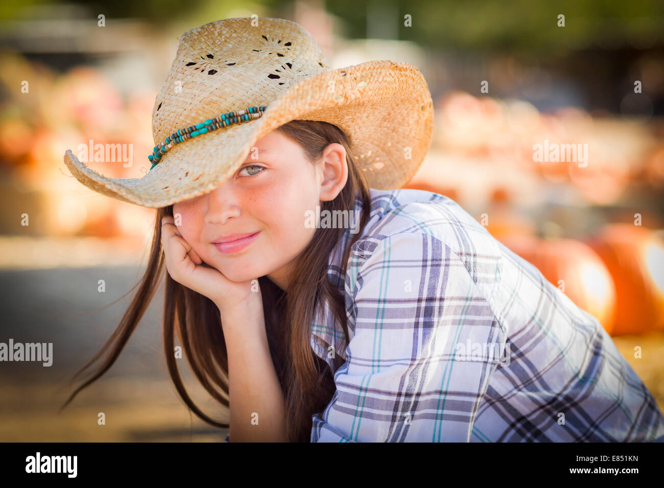 Jolie Preteen Girl Wearing Cowboy Hat Portrait à la citrouille dans un cadre rustique. Banque D'Images