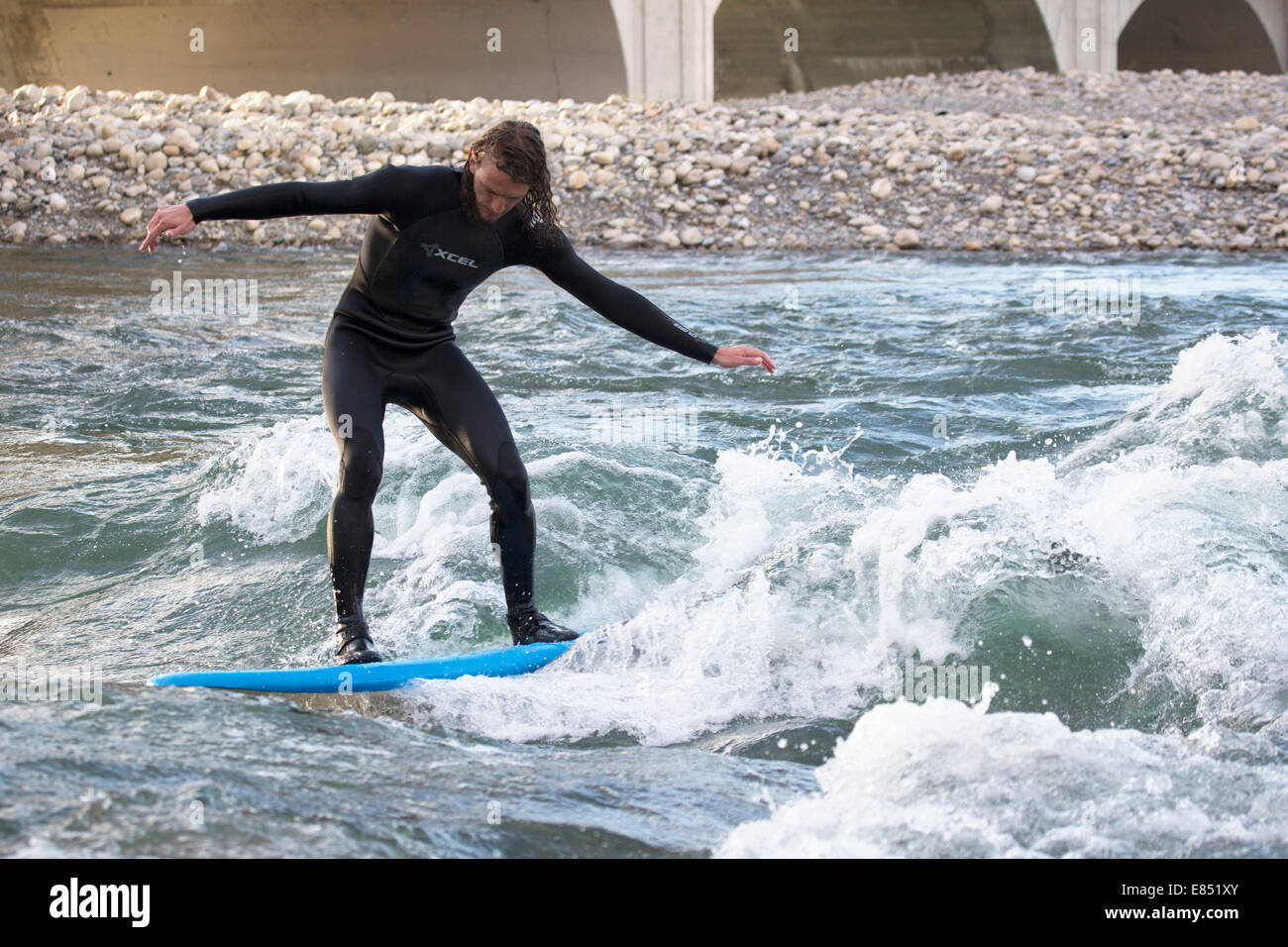 River surfer sur la rivière Bow dans le centre-ville de Calgary. L'onde stationnaire a été créé par une crue en 2013. Banque D'Images