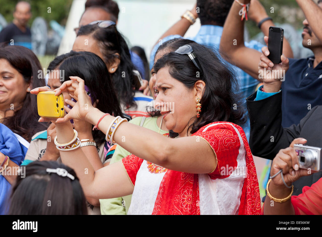 Femme indienne l'enregistrement vidéo d'un événement à l'aide de smart phone - USA Banque D'Images