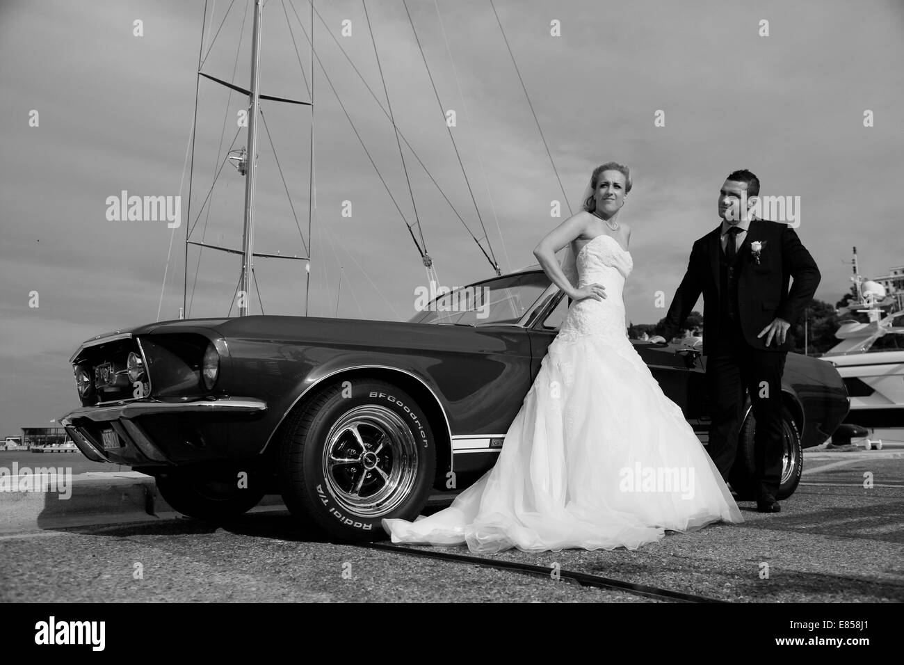 Bride and Groom posant devant une Ford Mustang dans un port Banque D'Images