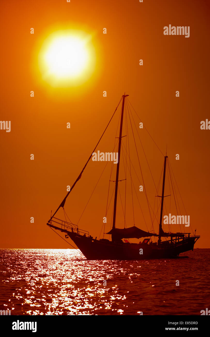 Silhouette de voile yacht vintage dans la mer tropicale au coucher du soleil. Thaïlande Banque D'Images