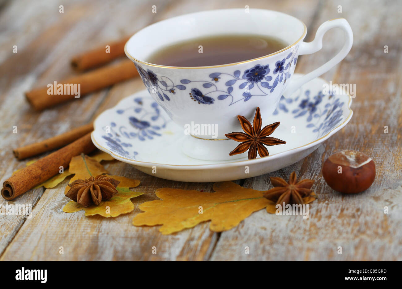 Tasse de thé, l'anis étoilé, la cannelle, les feuilles d'automne et châtaignes Banque D'Images