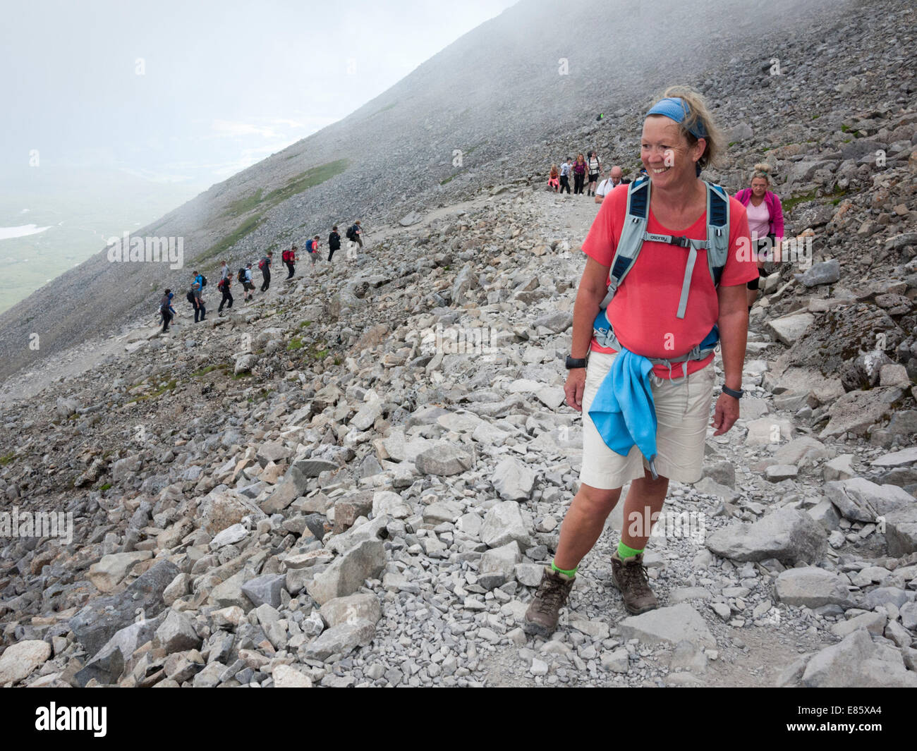 Une femme sur le chemin touristique jusqu'à Ben Nevis encombrée de marcheurs, Ecosse UK Banque D'Images