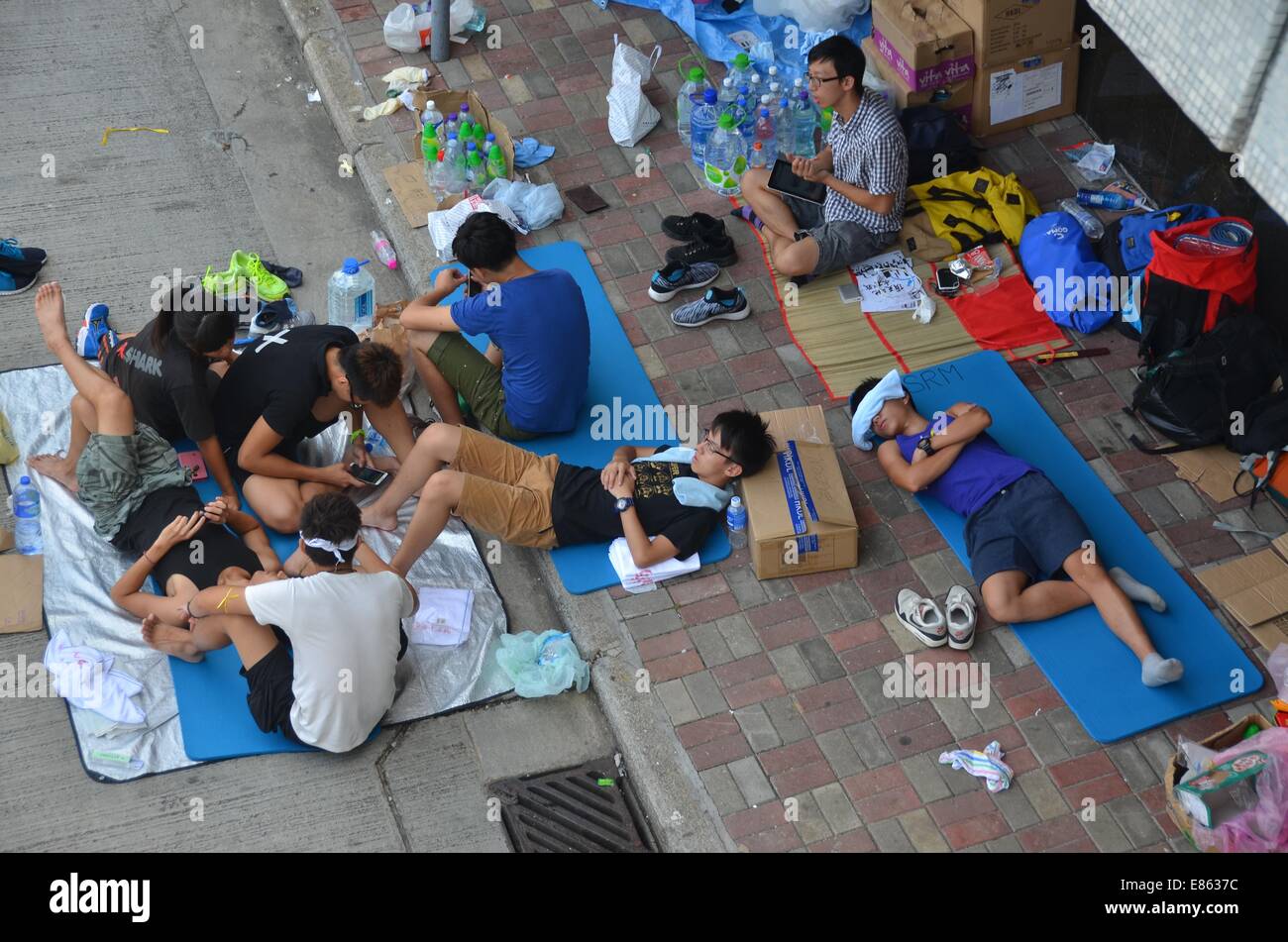 Le mercredi 1er octobre 2014, un jour férié pour marquer le 65e anniversaire de la fondation de la République populaire de Chine, des protestataires se reposer alors que des milliers de jeunes participent à la quatrième journée de la manifestation pro-démocratie connu comme 'Central' OCCUPER, bloquer la circulation sur les routes principales dans le centre-ville de Hong Kong. L'ambiance continue d'être calme et non-violent, alors que trois jours plus tôt, des manifestants devant les gaz lacrymogènes et du poivre de cayenne à partir de la police en tenue anti-émeute complète. Credit : Stefan Irvine/Alamy Live News Banque D'Images