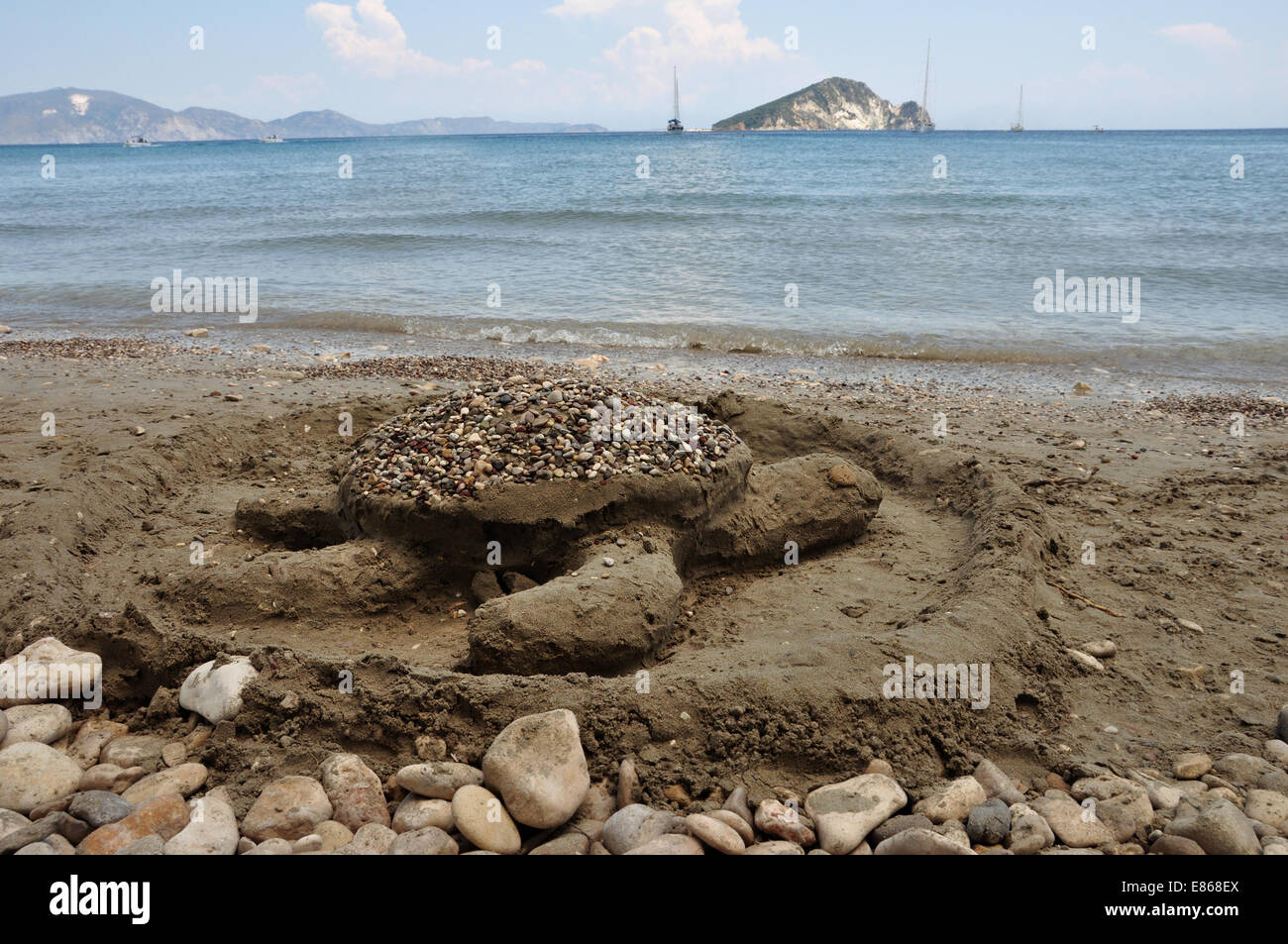 Carreta sculptures de sable des tortues de mer sur la plage de Keri et vue lointaine de l'îlot Marathonisi. Banque D'Images Carreta sculptures de sable des tortues de mer sur la plage de Keri et vue lointaine de l'îlot Marathonisi. Banque D'Images