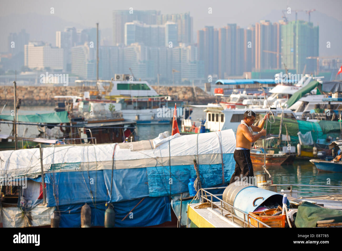 L'homme chinois sur un bateau dans le village flottant. Causeway Bay Typhoon Shelter, Hong Kong. Banque D'Images