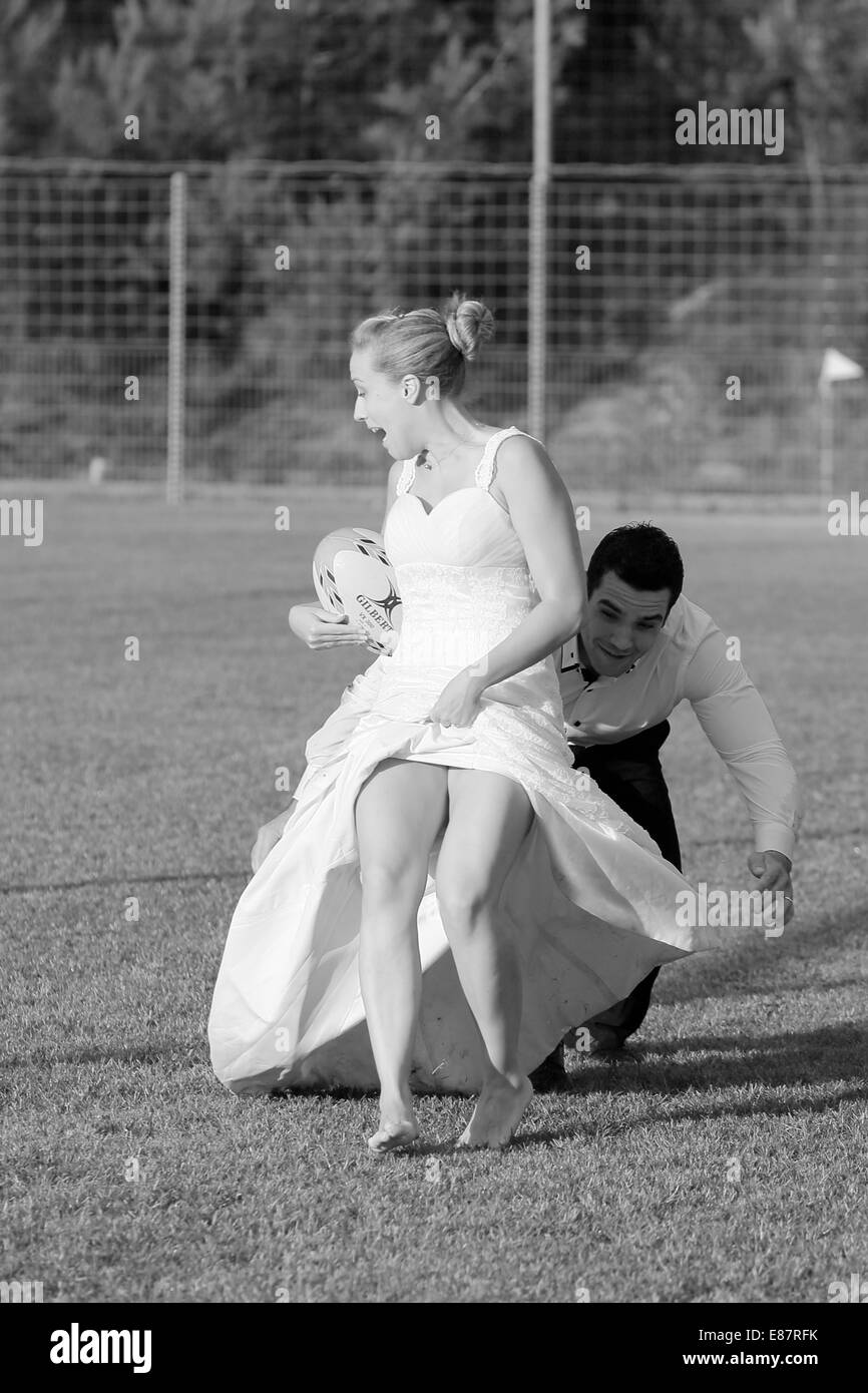 Corbeille la robe, mariée et le marié à jouer au rugby, le marié s'attaquer à la mariée Banque D'Images