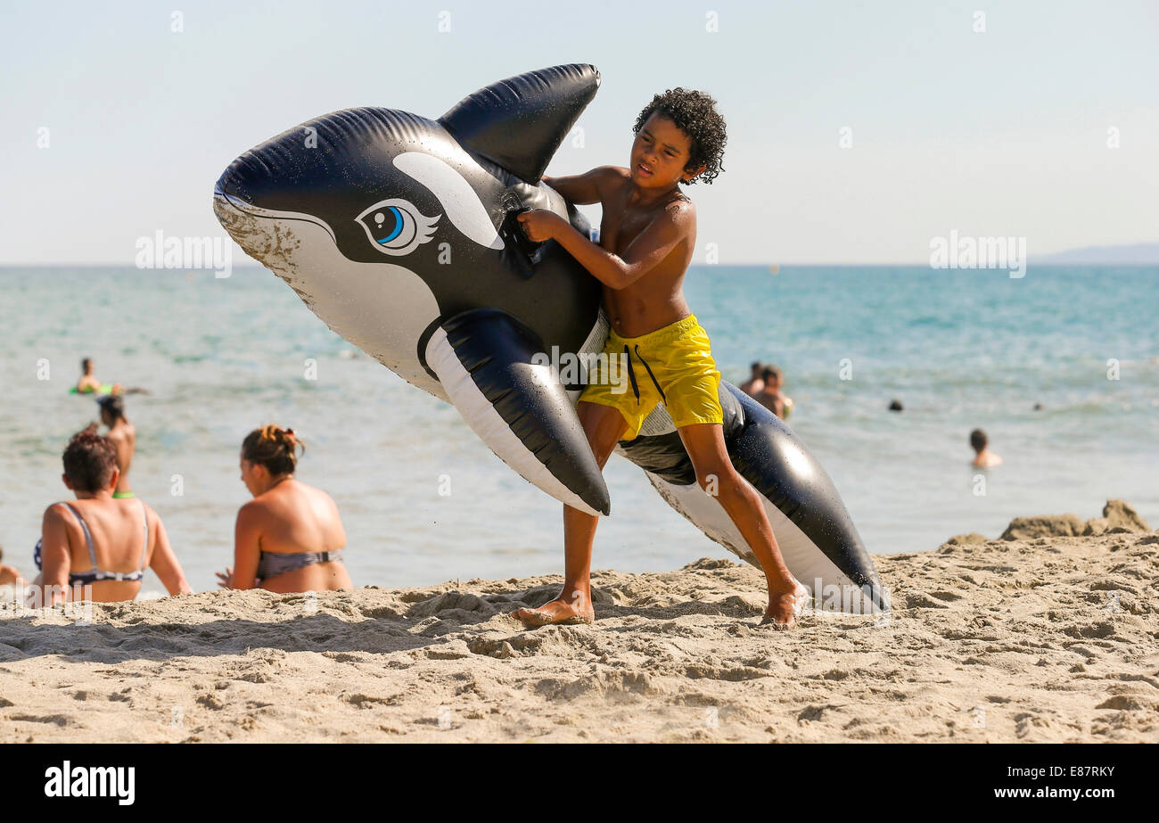 Garçon avec un jouet de l'eau gonflable sur la plage, Ghisonaccia, Corse,  France Photo Stock - Alamy