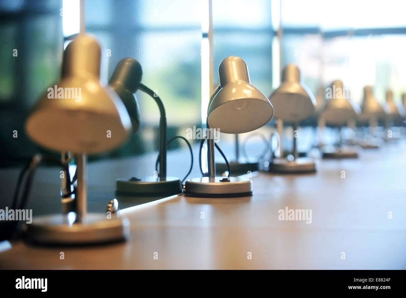 Plusieurs lampes de lecture dans une bibliothèque rangée sur un bureau Banque D'Images