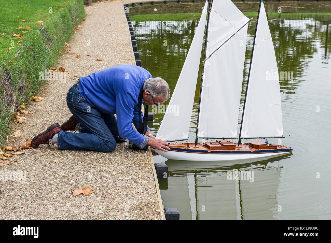 Un passionné de bateau modèle de lancer son yacht modèle sur un lac à Maldon dans l'Essex. Banque D'Images