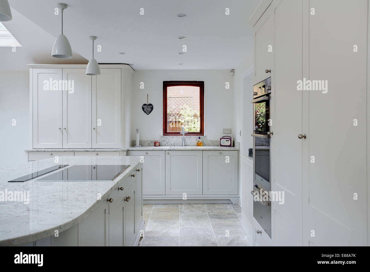 Une cuisine moderne blanc avec plan de travail en granite. Banque D'Images