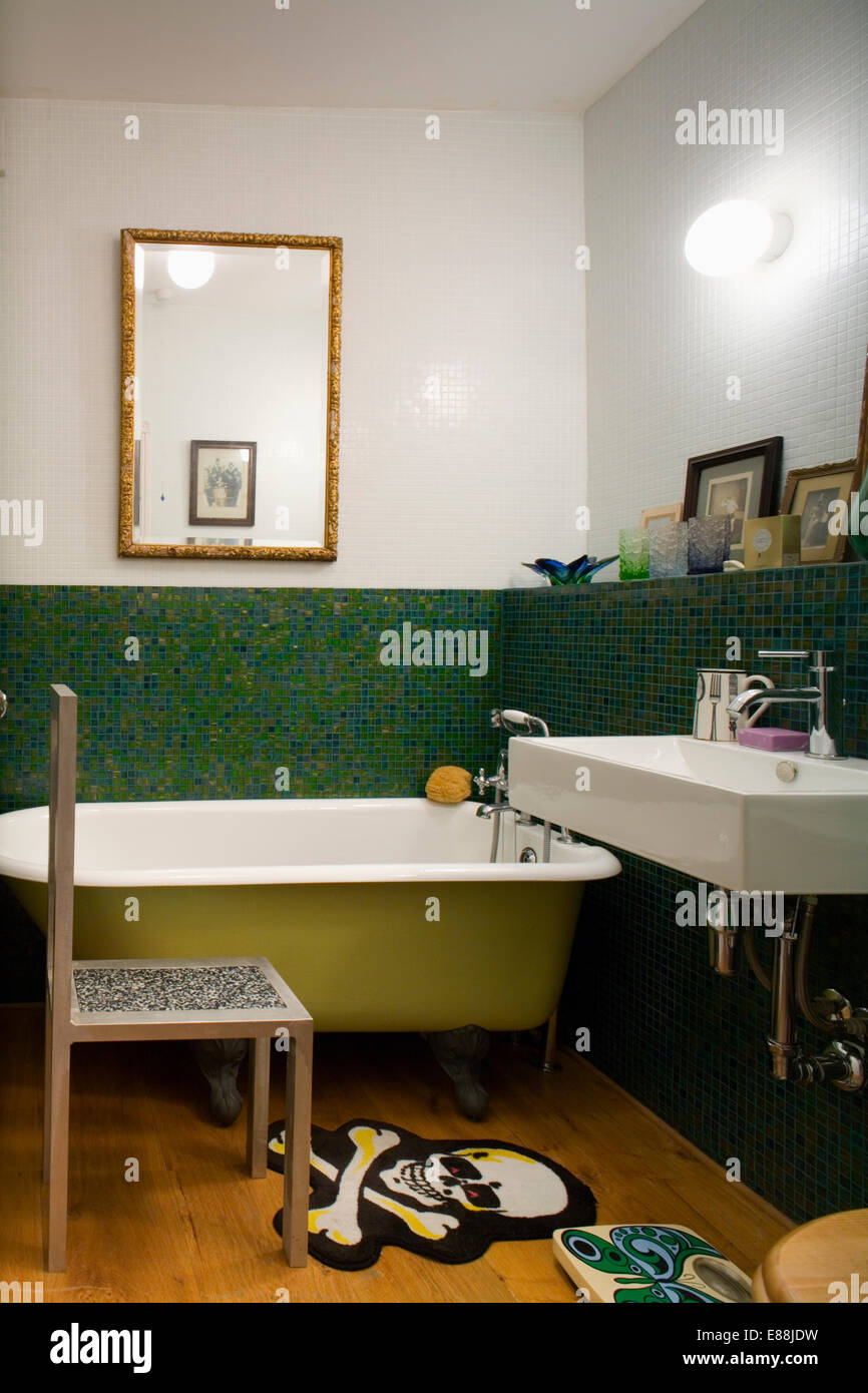 Les carreaux de mur en mosaïque et couvercle cylindrique en salle de bains  moderne avec baignoire chaise traditionnelle et tapis de tête de mort Photo  Stock - Alamy