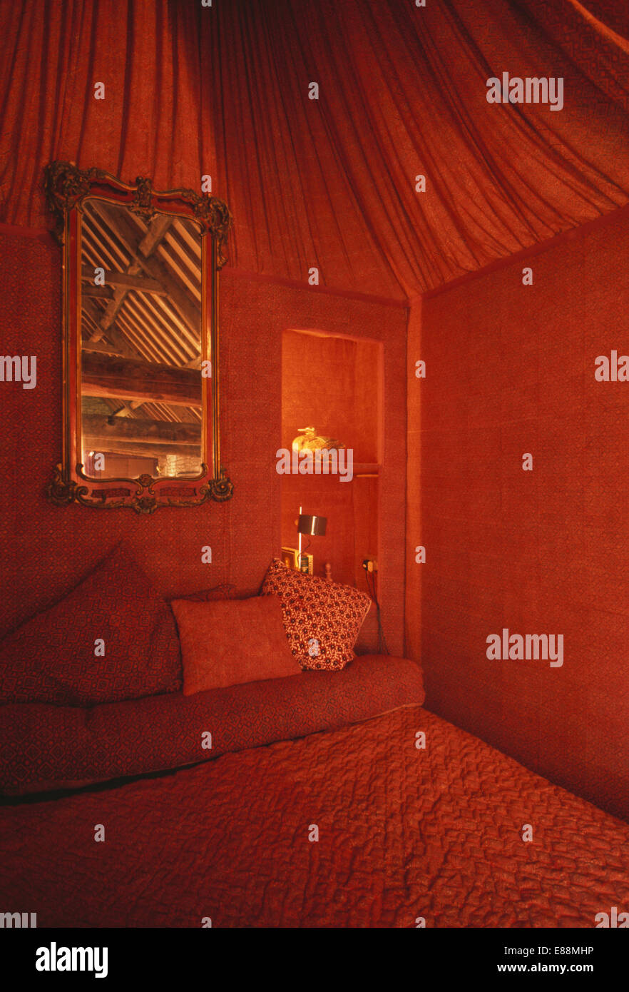 Miroir au-dessus de lit dans la chambre à coucher des années 70 aux murs  rouges et de linge et plafond de toile rouge Photo Stock - Alamy
