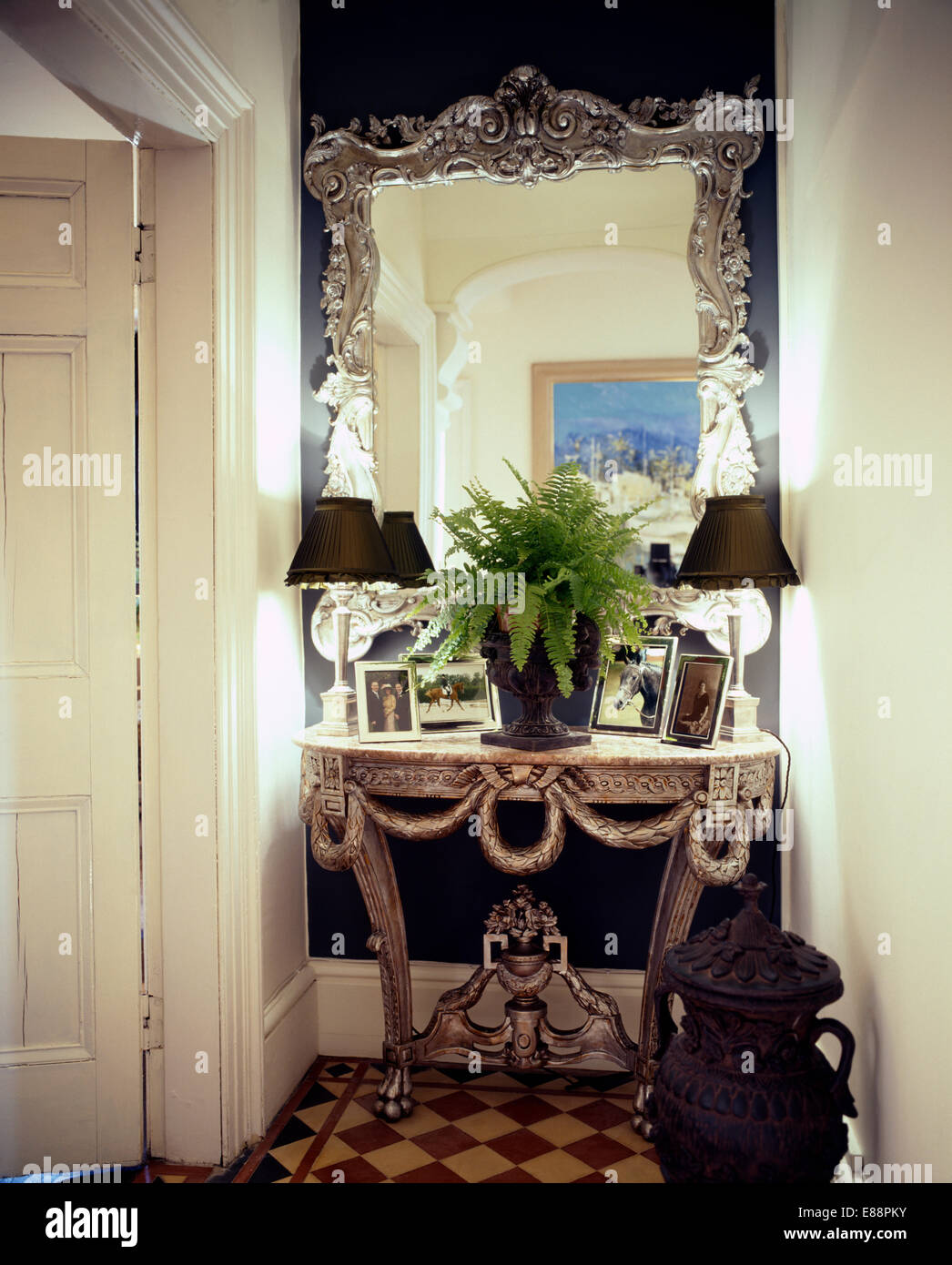 Miroir encadré de métal ouvragé au-dessus de table console avec plante et  noir lampes dans la salle traditionnelle Photo Stock - Alamy