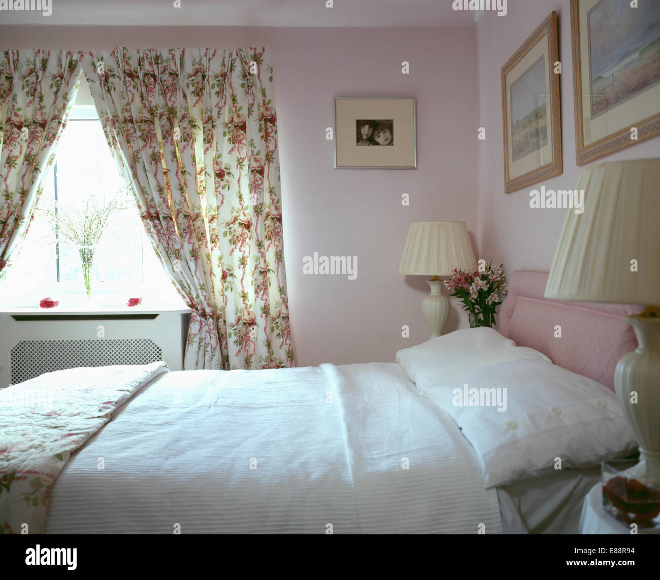 Oreillers blanc et double-couvercle sur le lit dans une chambre rose ... Oreillers blanc et double-couvercle sur le lit dans une chambre rose ...