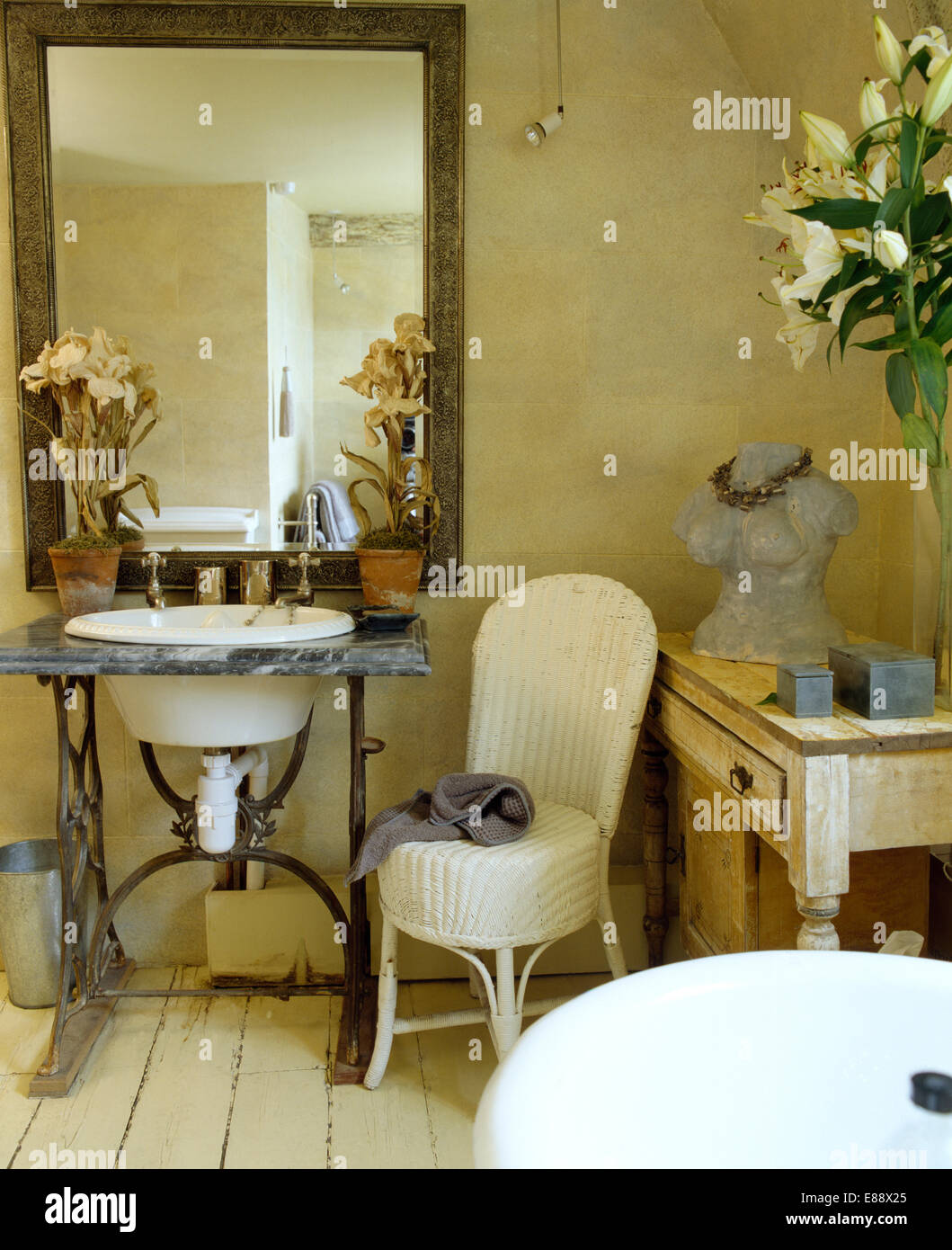 Grand miroir au-dessus du lavabo équipé en vintage table de la machine à coudre dans la salle de bain pays avec chaise en rotin blanc Banque D'Images