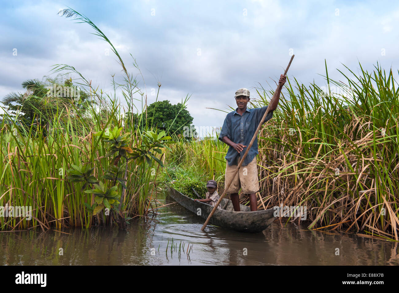 Homme malgache et son fils dans un petit bateau, Maroantsetra, Madagascar, Afrique Banque D'Images