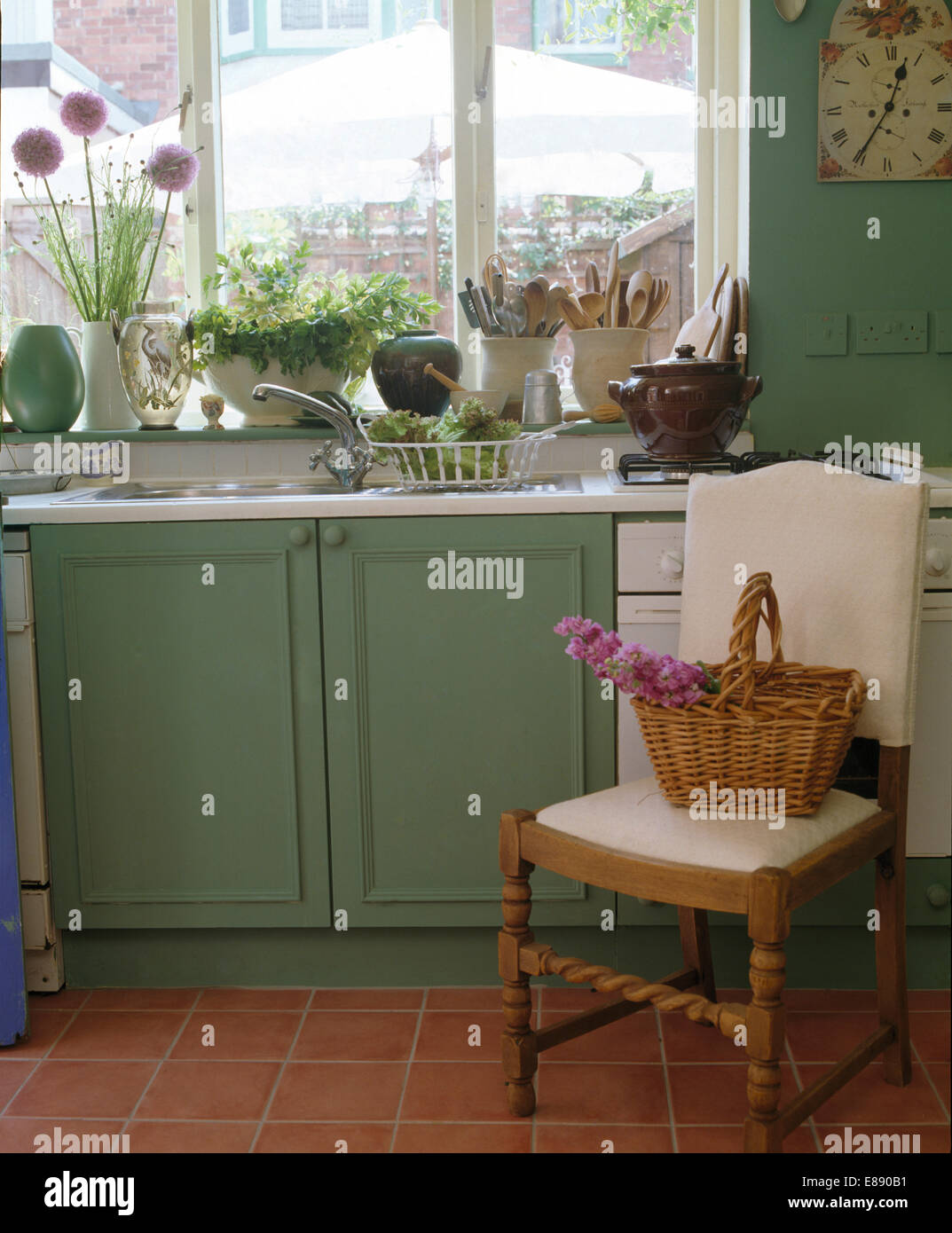 Panier en osier sur la crème d'un fauteuil rembourré en vert pâle cuisine  cottage Photo Stock - Alamy