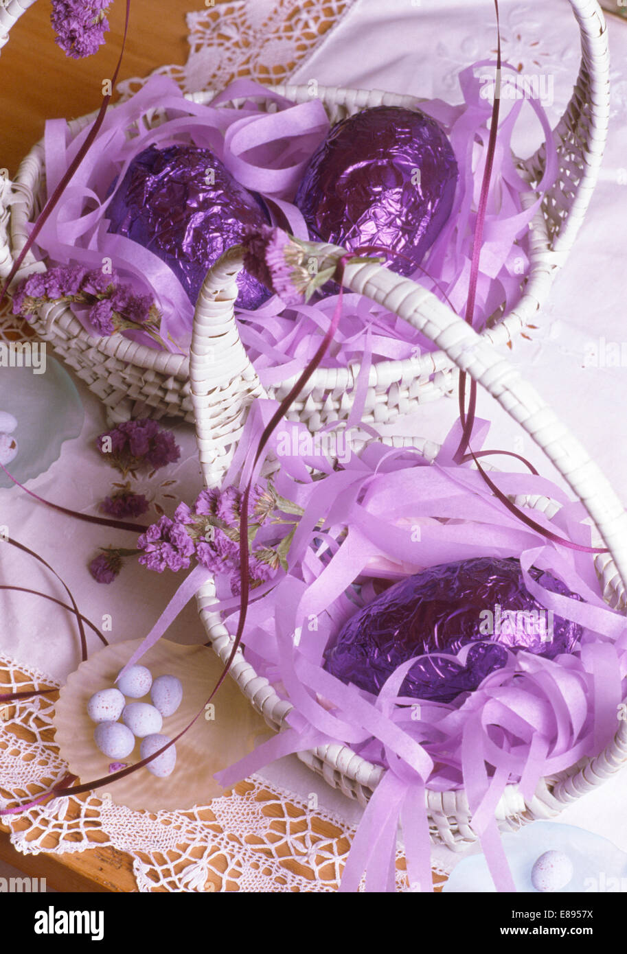 Still-Life de paniers d'oeufs de Pâques couverte d'aluminium violet avec ruban mauve Banque D'Images
