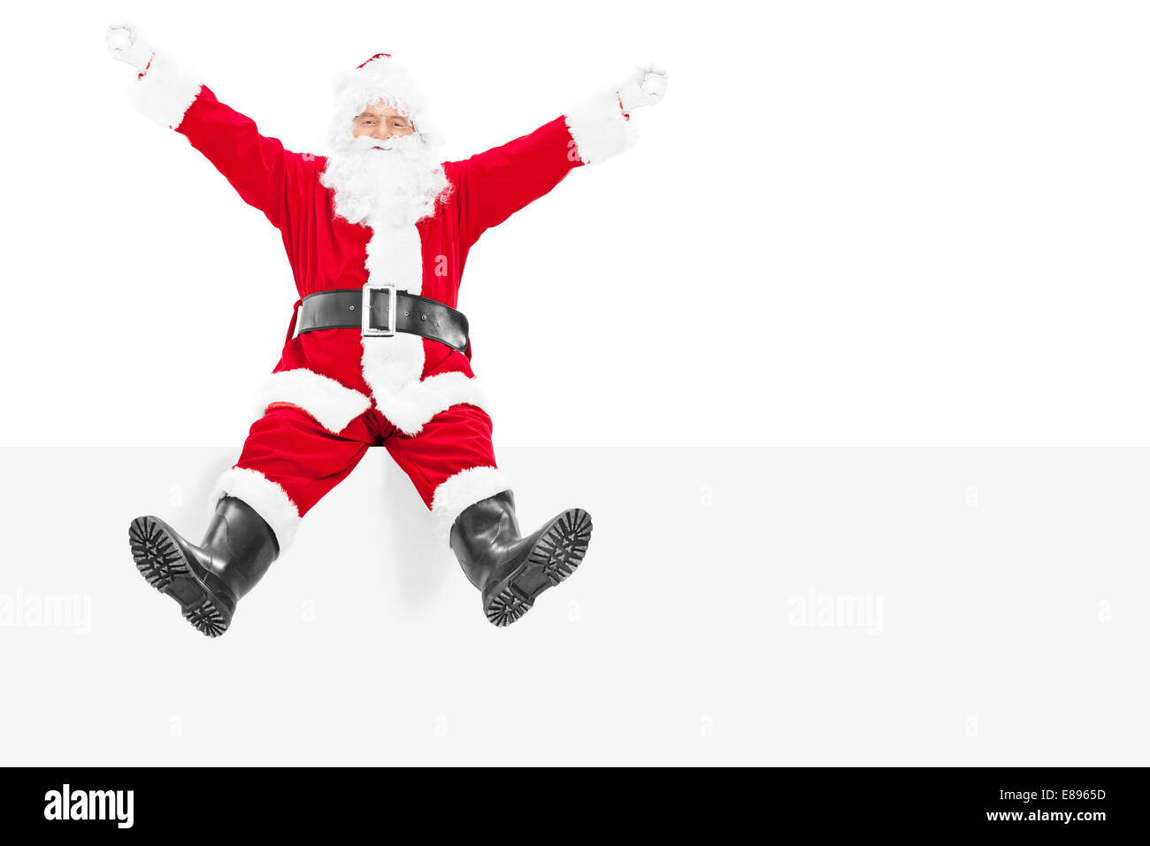 Heureux Père Noël assis sur un panneau vide isolé sur fond blanc Banque D'Images