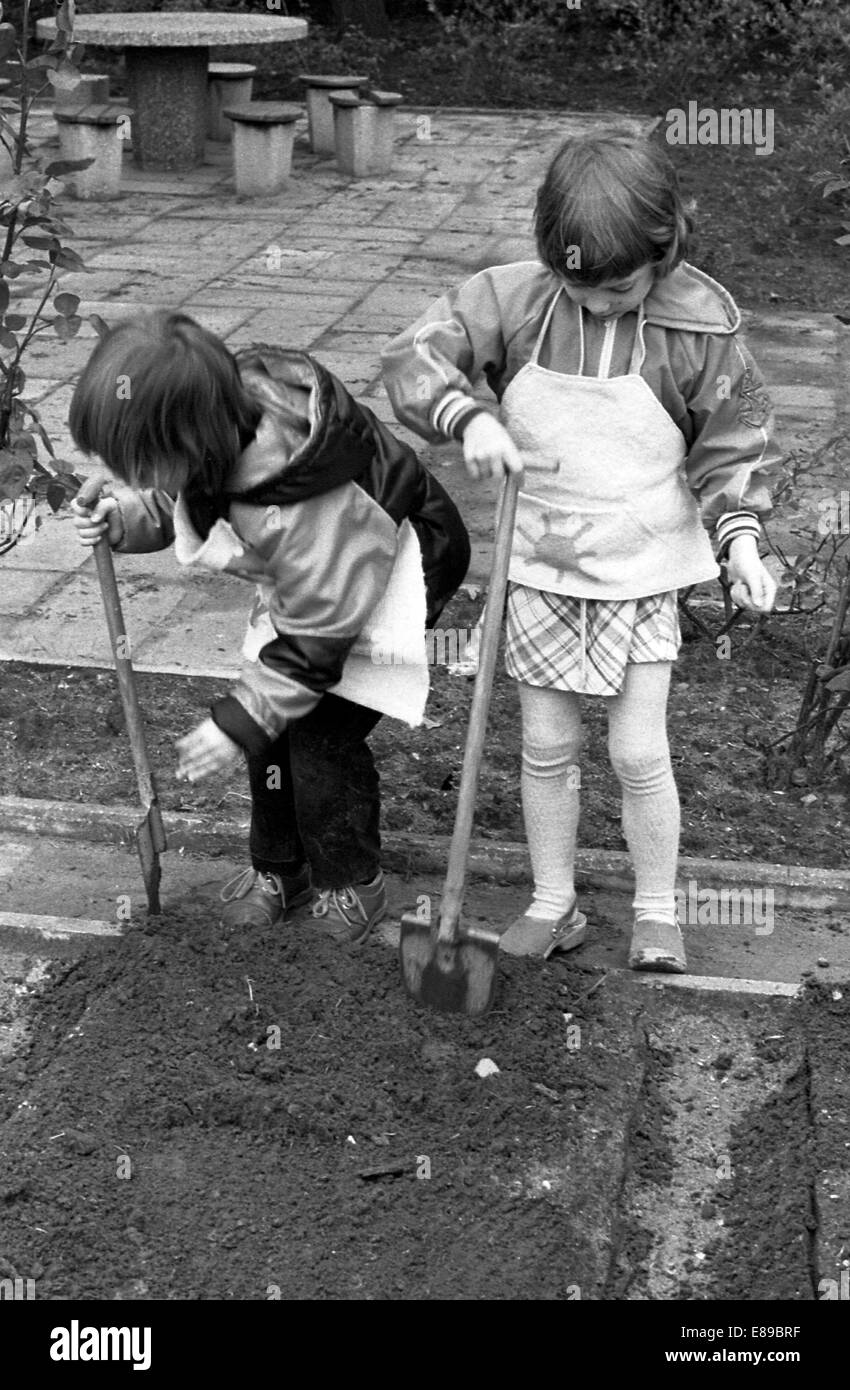 Berlin, DDR, les enfants d'âge préscolaire qui travaillent dans le jardin dans le jardin de l'école Banque D'Images Berlin, DDR, les enfants d'âge préscolaire qui travaillent dans le jardin dans le jardin de l'école Banque D'Images