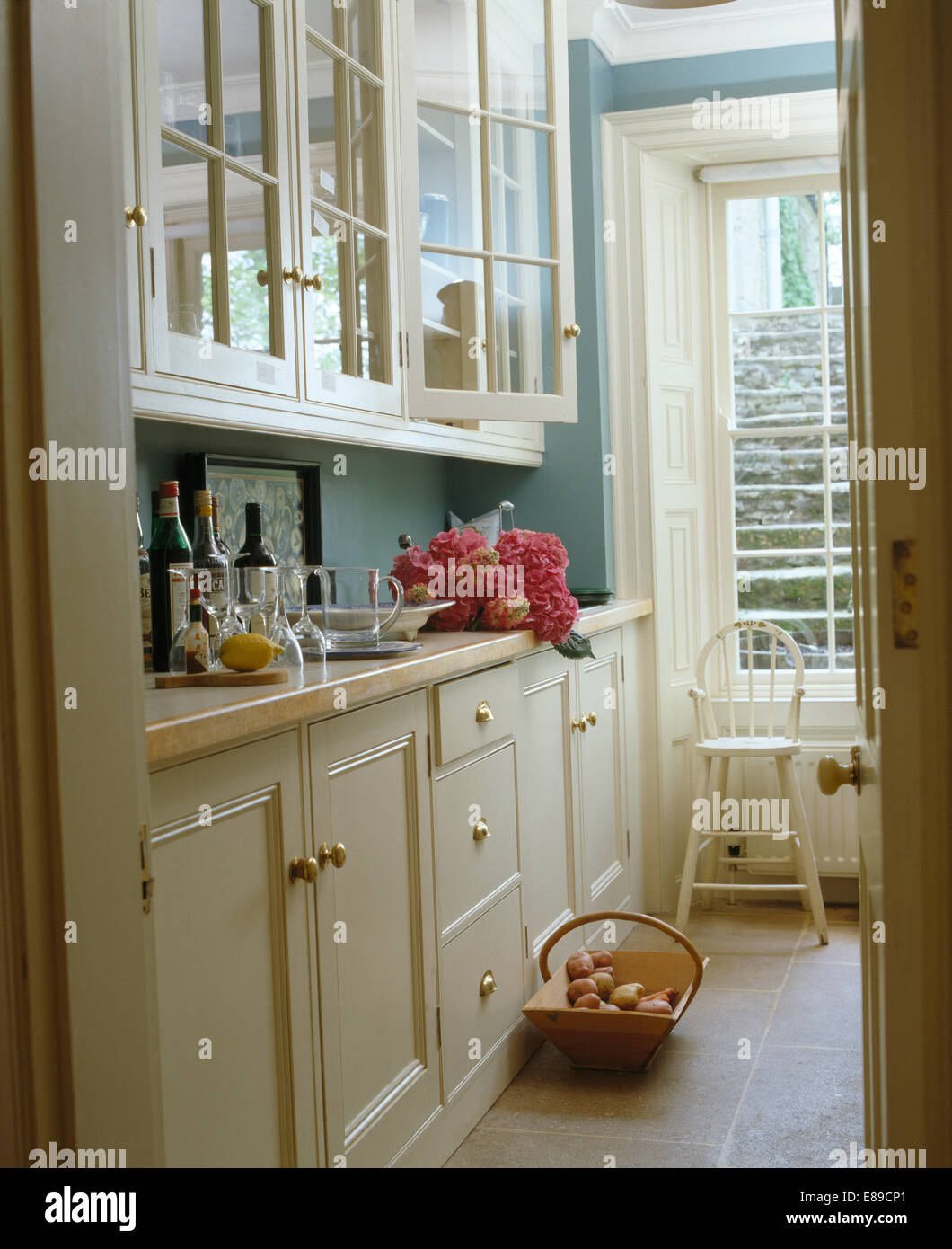 Placards blanc turquoise pâle en cuisine avec un sol en pierre Banque D'Images