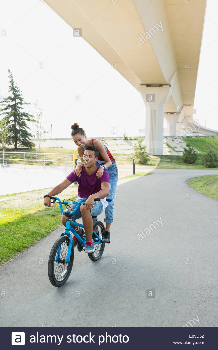 Teenage couple riding bicycle Banque D'Images