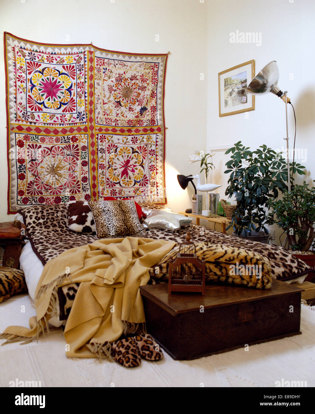 Chambre avec un grand mur de coton fleurs suspendues au-dessus de lit en  fausse peau d'animaux coussins et jetés Photo Stock - Alamy